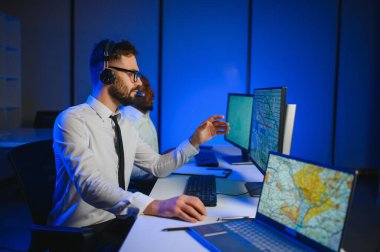 Tamirat merkezi. Seyrüsefer kontrol panosunda otururken mikrofonla çalışan erkeklerin portresi.