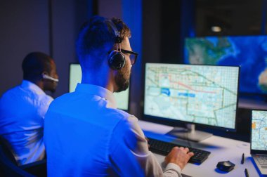 Tamirat merkezi. Seyrüsefer kontrol panosunda otururken mikrofonla çalışan erkeklerin portresi.