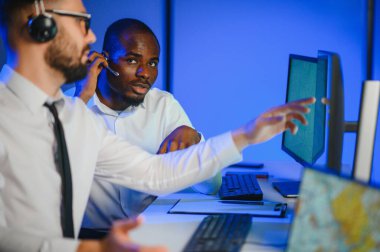 Tamirat merkezi. Seyrüsefer kontrol panosunda otururken mikrofonla çalışan erkeklerin portresi.