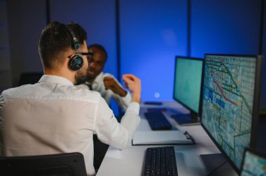 Tamirat merkezi. Seyrüsefer kontrol panosunda otururken mikrofonla çalışan erkeklerin portresi.