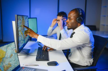 Tamirat merkezi. Seyrüsefer kontrol panosunda otururken mikrofonla çalışan erkeklerin portresi.