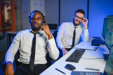 Tamirat merkezi. Seyrüsefer kontrol panosunda otururken mikrofonla çalışan erkeklerin portresi.