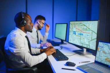 Erkek Veri Bilimadamı, Büyük Altyapı Kontrol ve İzleme Odası 'nda Kulaklık Takan Kişisel Bilgisayarda Çalışıyor. İş Çağrı Merkezi Ofisi 'nde Genç Mühendis