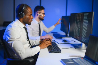 Tamirat merkezi. Seyrüsefer kontrol panosunda otururken mikrofonla çalışan erkeklerin portresi.