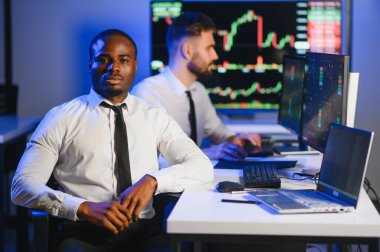 Takım çalışması kavramı. Borsacılardan oluşan bir ekip modern ofiste birçok ekran ekranı ile çalışır..