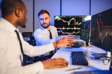 Takım çalışması kavramı. Borsacılardan oluşan bir ekip modern ofiste birçok ekran ekranı ile çalışır..