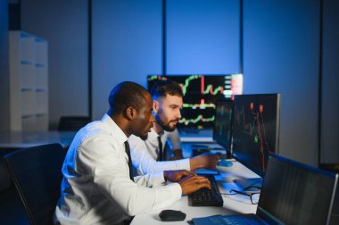 Takım çalışması kavramı. Borsacılardan oluşan bir ekip modern ofiste birçok ekran ekranı ile çalışır..