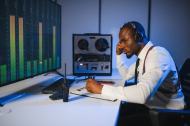 Gizli ajan kayıt cihazını dinliyormuş. Memur kulaklıkla dinleme yapıyor..