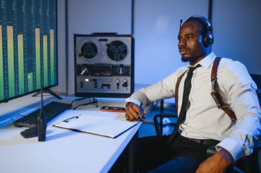 Gizli ajan kayıt cihazını dinliyormuş. Memur kulaklıkla dinleme yapıyor..