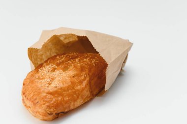 Brezilya hamur işi beyaz arka planda kahverengi kağıda sarılı..