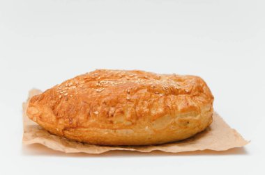 Brezilya hamur işi beyaz arka planda kahverengi kağıda sarılı..