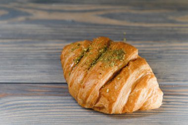 Ahşap arka planda izole edilmiş taze kruvasan..