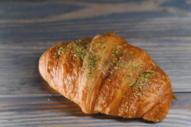 Ahşap arka planda izole edilmiş taze kruvasan..