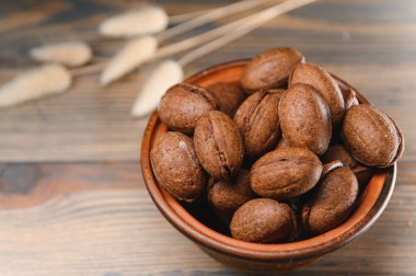 Ahşap zemin üzerinde kaynamış konsantre süt ile lezzetli fındık şekilli kurabiyeler..