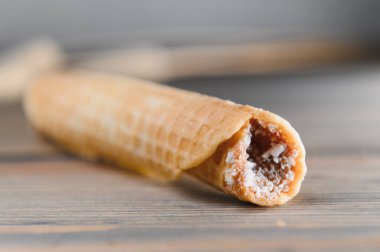 Ahşap zemin üzerinde kaynamış yoğunlaştırılmış sütle lezzetli gofretler..