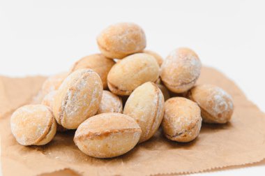 Lezzetli fındık şekilli kurabiyeler ve beyaz arka planda haşlanmış konsantre süt..