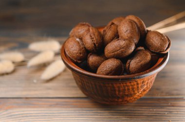 Ahşap zemin üzerinde kaynamış konsantre süt ile lezzetli fındık şekilli kurabiyeler..