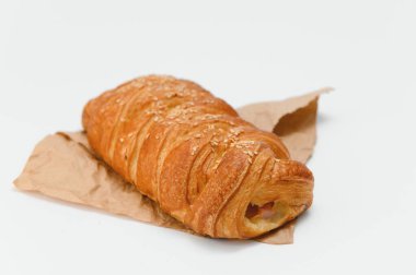 Brezilya hamur işi beyaz arka planda kahverengi kağıda sarılı..