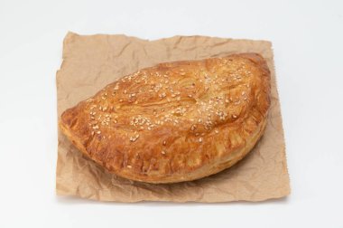 Brezilya hamur işi beyaz arka planda kahverengi kağıda sarılı..