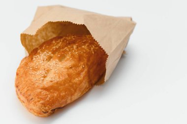 Brezilya hamur işi beyaz arka planda kahverengi kağıda sarılı..