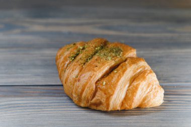 Ahşap arka planda izole edilmiş taze kruvasan..