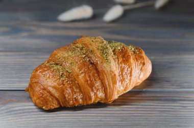 Ahşap arka planda izole edilmiş taze kruvasan..