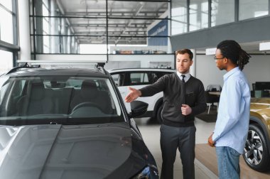 Bir araba galerisinde danışman, müşteriye yeni bir araba seçmesinde yardımcı olur..