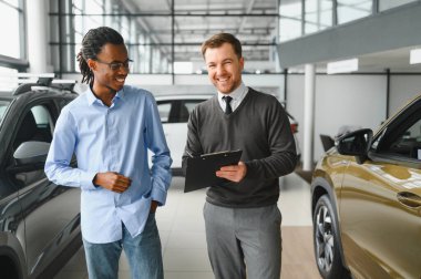 Bir araba galerisinde danışman, müşteriye yeni bir araba seçmesinde yardımcı olur..