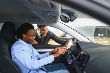 Bir araba galerisinde danışman, müşteriye yeni bir araba seçmesinde yardımcı olur..