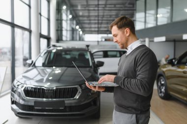 Modern araba satıcısının portresi fotokopi alanı olan bir araba salonunda duruyor..