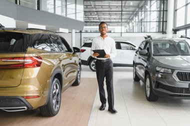 Modern araba satıcısının portresi fotokopi alanı olan bir araba salonunda duruyor..