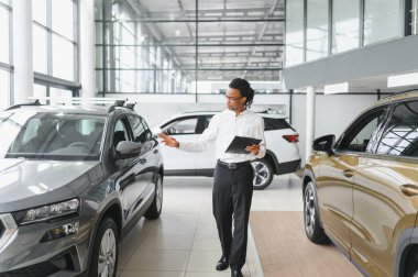 Afro-Amerikan araba satıcısı, galeride duruyor..