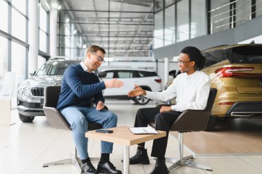 Kafkasyalı satış temsilcisi ve Afrikalı müşteri bayilikte el sıkışırken, satışı kabul ettiler..