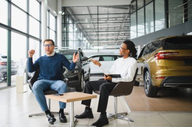 Adamın biri yeni bir arabanın anahtarlarını tutuyor. Arabayı almak için bir satıcıyla sözleşme imzalandı..