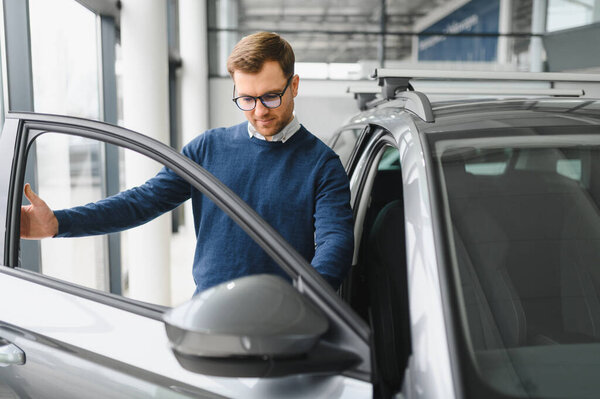 Handsome bearded buyer in casual wear in dealership.