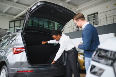 Araba Satış Müdürü Oto Alıcıya Gösteriyor Lüks Otomobil Galerisinde Duruyor.