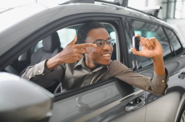 Afro-Amerikalı bir adam galeriden araba alıyor..