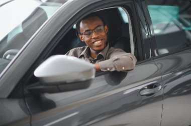 Genç adam yeni bir araç içinde araba Bayilik seçmektir.