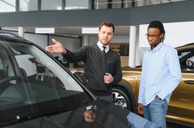Bir araba galerisinde danışman, müşteriye yeni bir araba seçmesinde yardımcı olur..