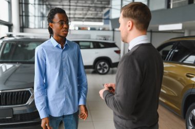 Bir araba galerisinde danışman, müşteriye yeni bir araba seçmesinde yardımcı olur..