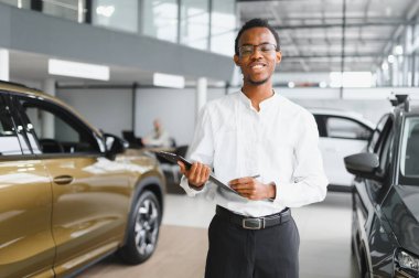 Afro-Amerikan araba satıcısı, galeride duruyor..