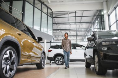 Yerel bayilikte yeni arabasının yanında poz veren mutlu bir Afrikalı adamın portresi..