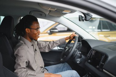 Afro-Amerikalı bir adam galeriden araba alıyor..