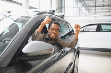 Genç adam yeni bir araç içinde araba Bayilik seçmektir.