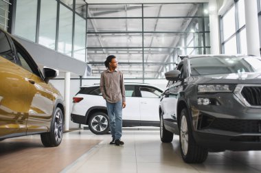 Afro-Amerikalı bir adam galeriden araba alıyor..