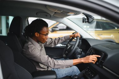 Afro-Amerikalı bir adam galeriden araba alıyor..