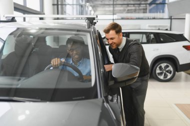 Bir araba galerisinde danışman, müşteriye yeni bir araba seçmesinde yardımcı olur..