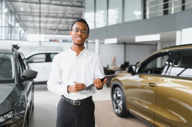 Modern araba satıcısının portresi fotokopi alanı olan bir araba salonunda duruyor..