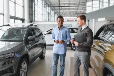 Bir araba galerisinde danışman, müşteriye yeni bir araba seçmesinde yardımcı olur..