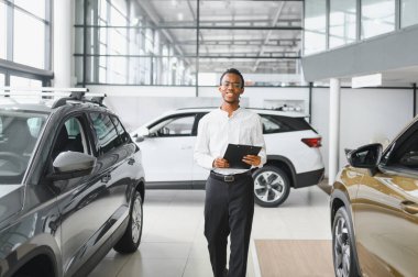 Modern araba satıcısının portresi fotokopi alanı olan bir araba salonunda duruyor..